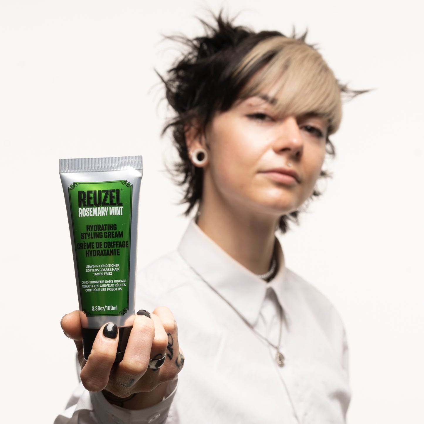 Reuzel Deutschland hydrating styling cream for hair, shown in a sleek bottle with a pump dispenser, part of the shop collection.