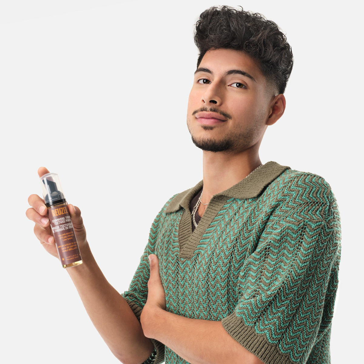 Reuzel Deutschland Grooming Tonic Texture Foam for hair styling, showing a foam bottle with textured hair in the background.