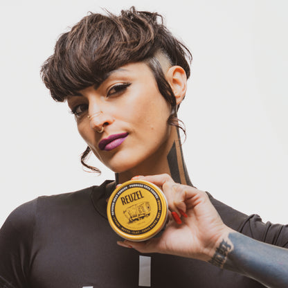 Reuzel Deutschland Severed Head Pomade bottle with Liquid Death branding, featuring a graphic severed head illustration on the label.