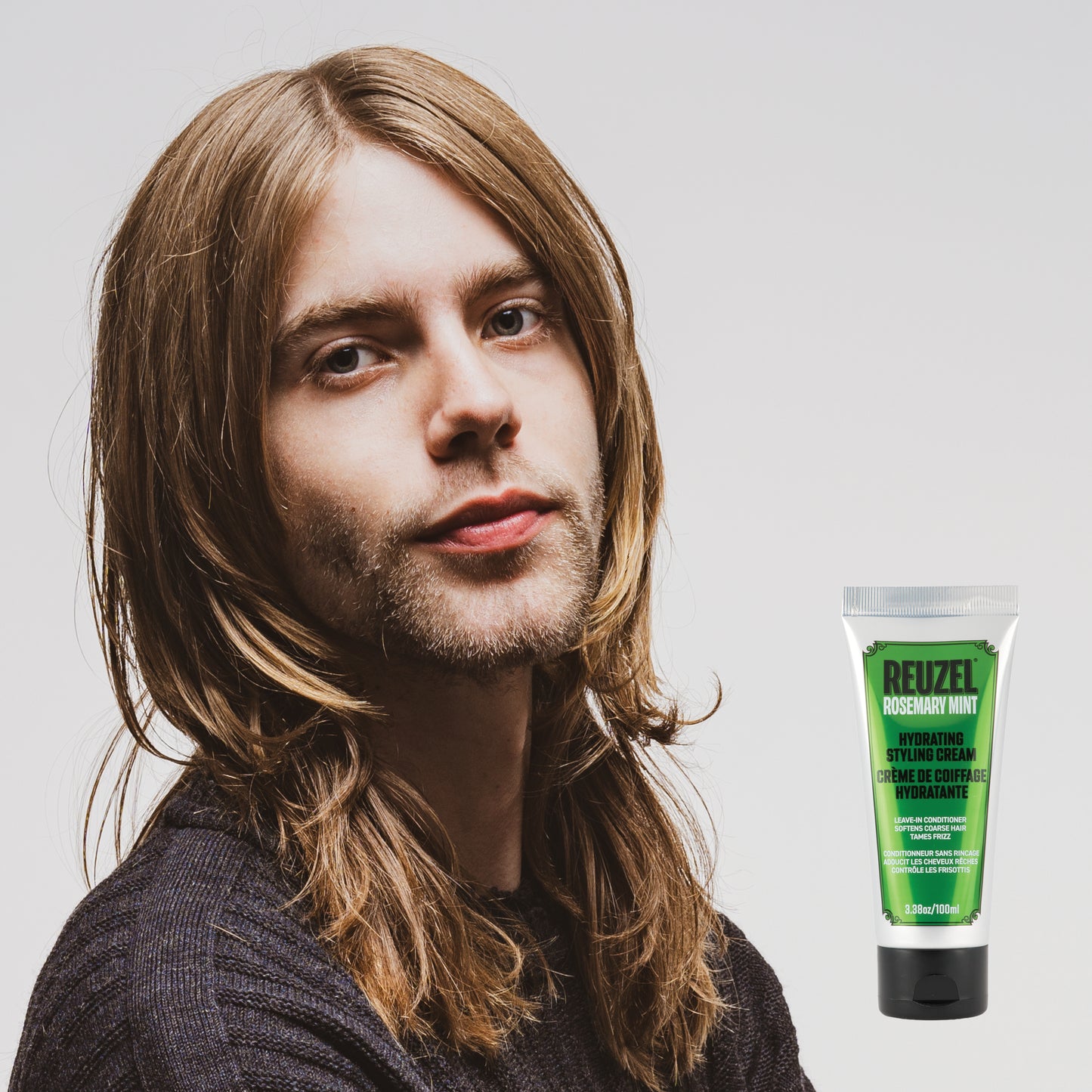 Reuzel Deutschland hydrating styling cream on hair, leave-in conditioner in a sleek tube for smooth, nourished hair styling.