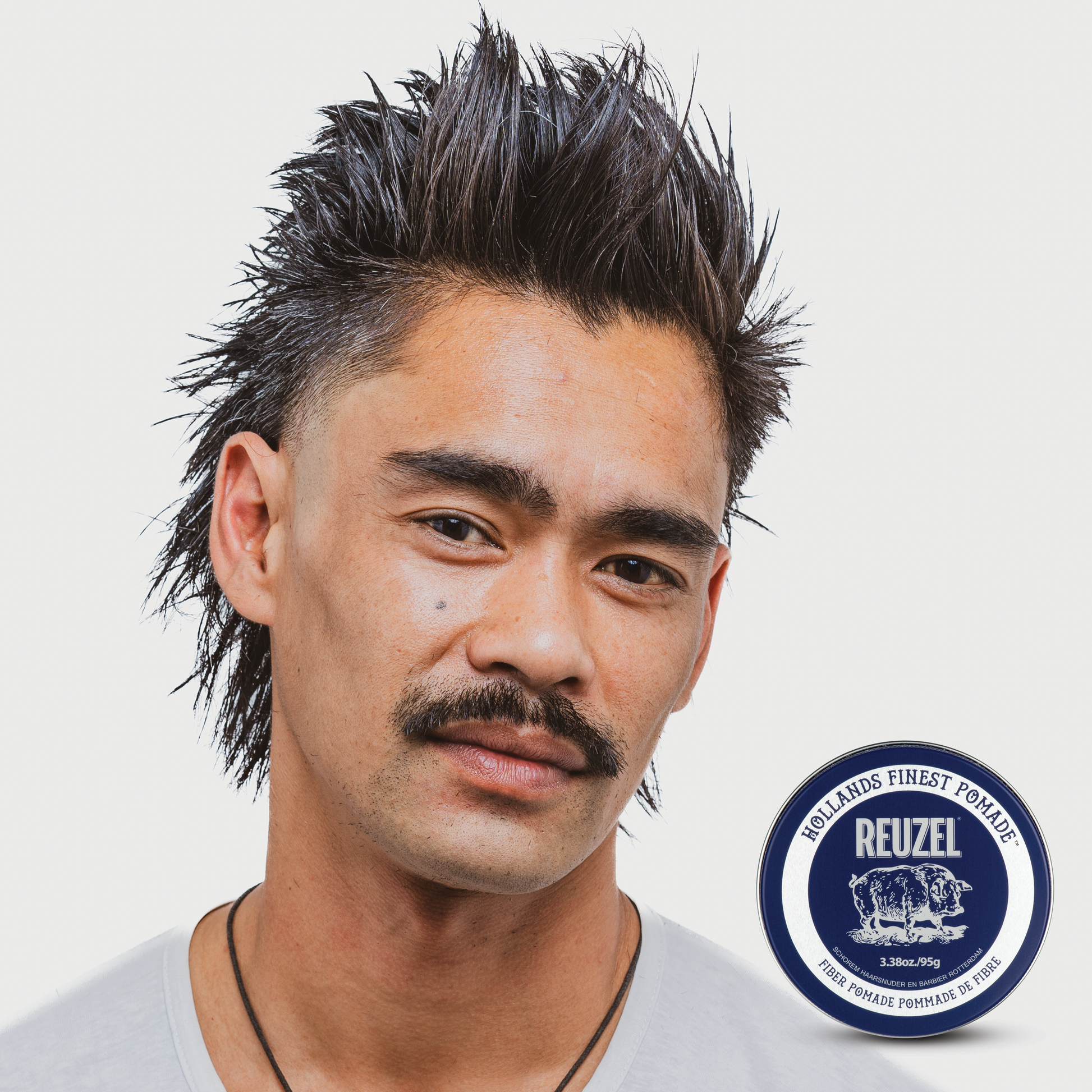 Reuzel Fiber Pomade jar with black lid and label, showcasing the grooming product for textured, flexible hold and shine.