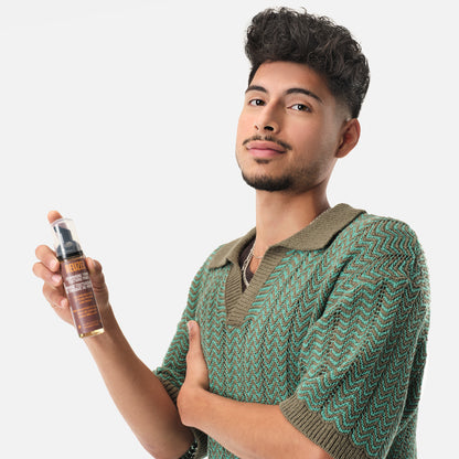 Reuzel Deutschland Grooming Tonic Texture Foam for hair styling, showing a foam bottle with textured hair in the background.