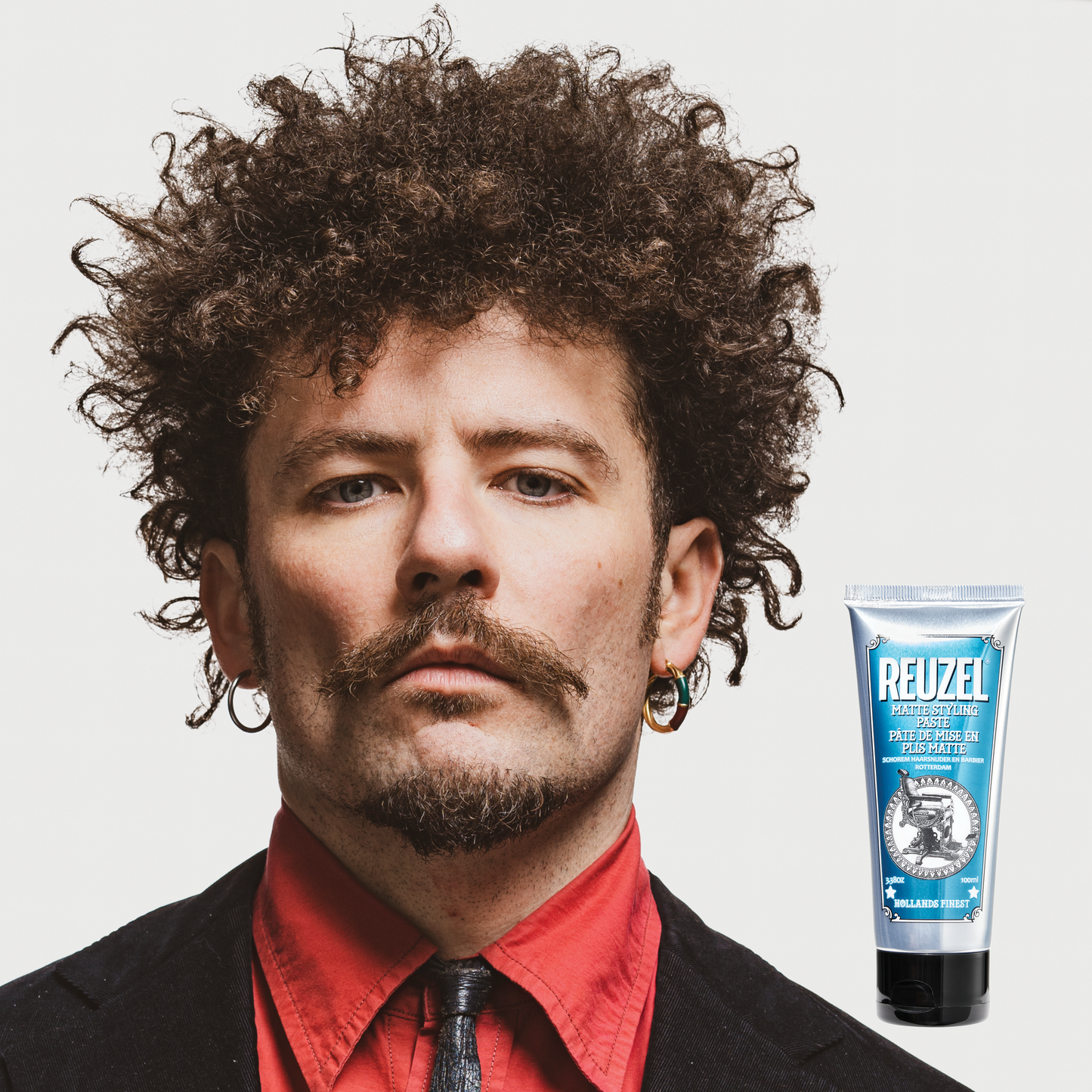 Reuzel Deutschland grooming cream for hair styling, showing the product container with a black lid and label on a plain background.