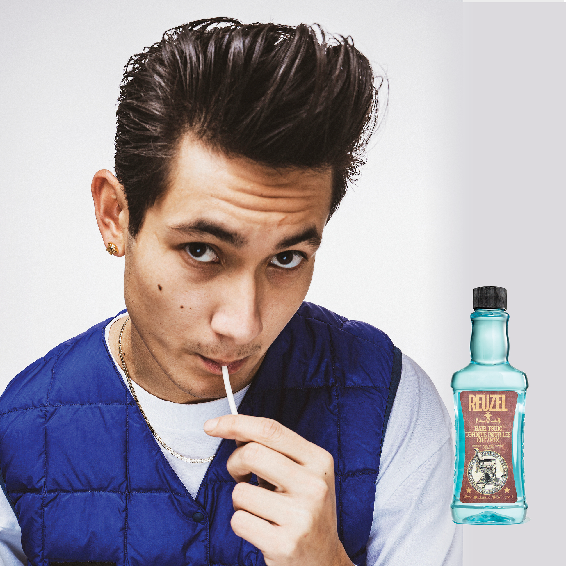 Reuzel Deutschland Hair Tonic bottle with label, showing the product's sleek design on a white background