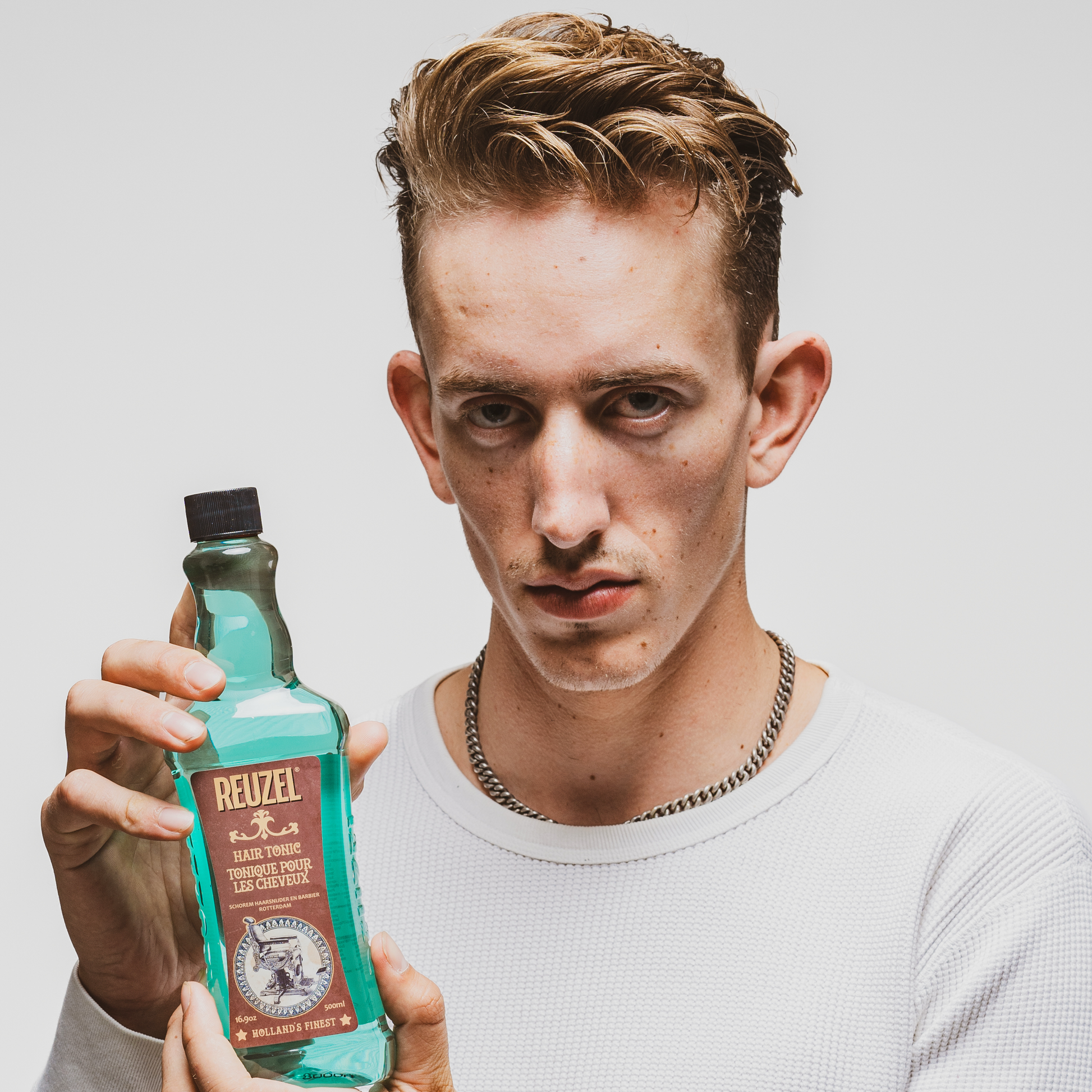 Reuzel Deutschland Hair Tonic bottle with label, featuring pump dispenser and sleek packaging on a plain background.