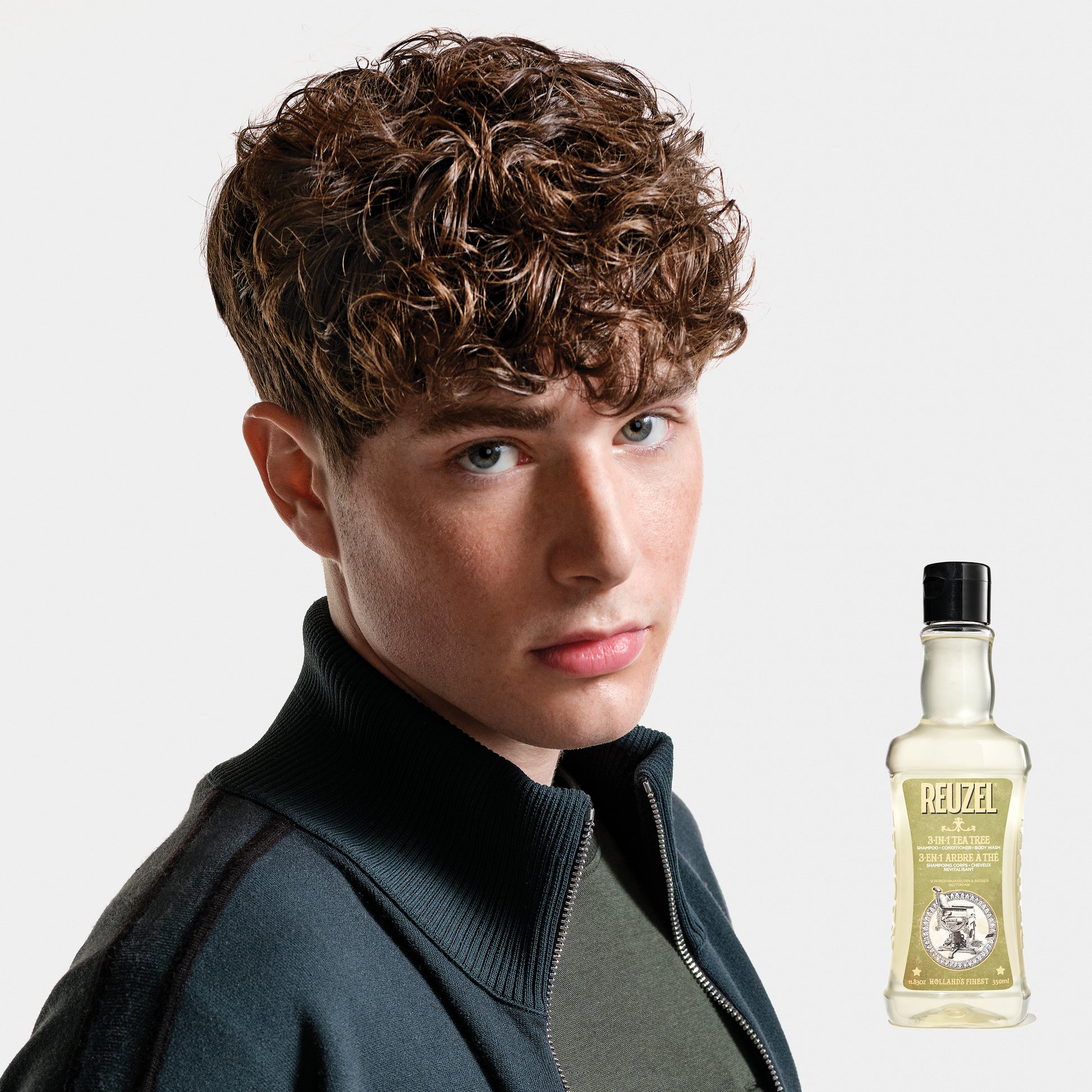 Reuzel Deutschland 3-in-1 tea tree shampoo, conditioner, and body wash bottle with label and pump dispenser.