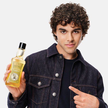 Reuzel Deutschland 3-in-1 tea tree shampoo, conditioner, and body wash bottle with label and pump dispenser.