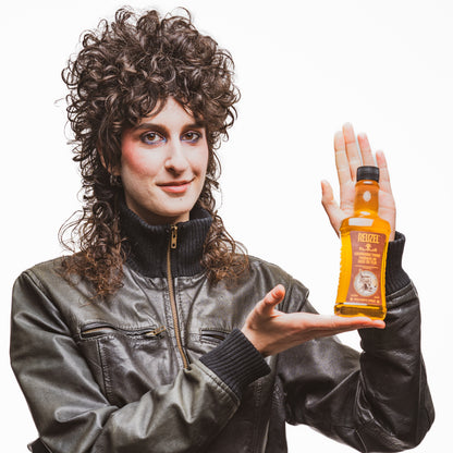 Reuzel Deutschland grooming tonic bottle, hair tonic product with label, displayed on a plain background.