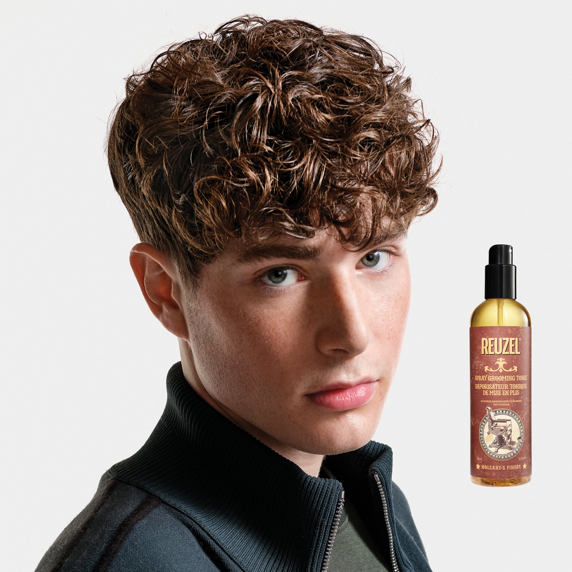 Reuzel Deutschland Spray Grooming Tonic bottle, hair tonic for styling and grooming, with a spray nozzle and label visible.