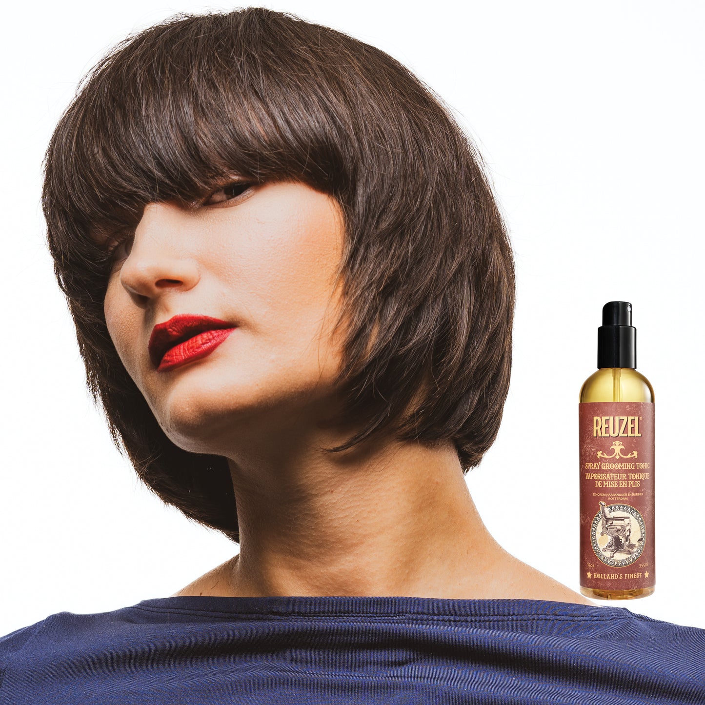 Reuzel Deutschland Spray Grooming Tonic hair tonic bottle with spray nozzle on a plain background.