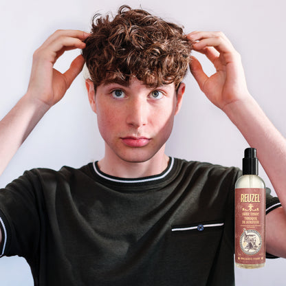 Reuzel Deutschland Surf Tonic salt spray hair tonic with a spray bottle and beachy textured hair, perfect for tousled seaside style.