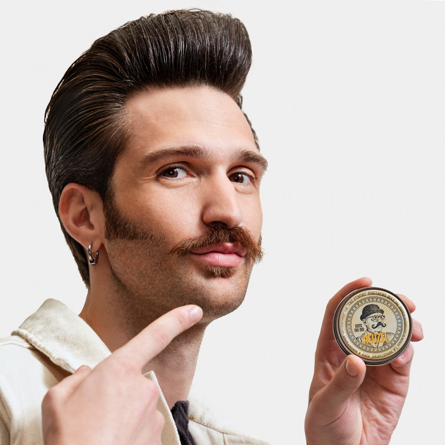 Reuzel Deutschland The Stache Mustache Wax jar with black lid and label, beard grooming product for mustache styling and shaping.