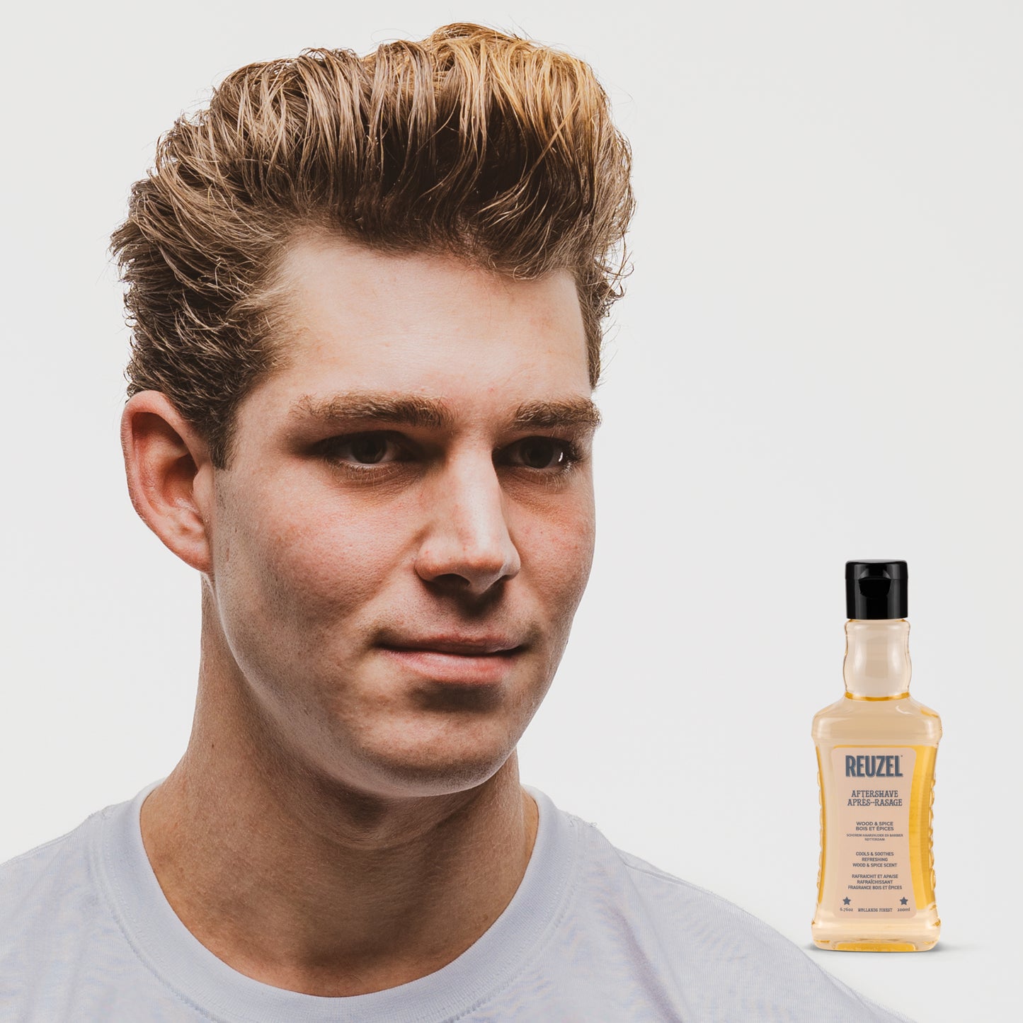 Reuzel Deutschland beard aftershave with wood and spice scent, featuring a bottle with a sleek label and a wooden cap.
